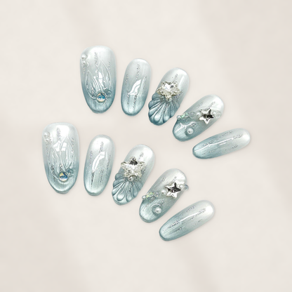 Glacial Mermaid Blue Oval Press-On Nails with Pearlescent Cat-Eye Shimmer, Sculpted Shells, Stars, and Silver Charms 22mm
