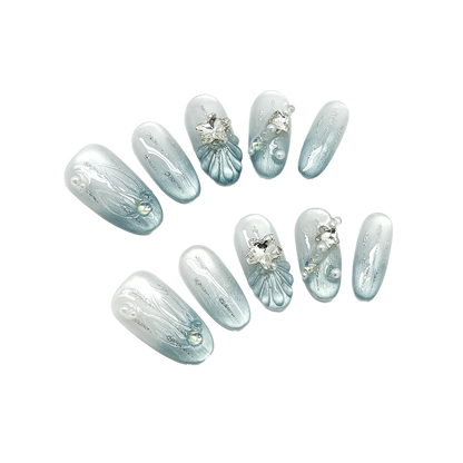 Glacial Mermaid Blue Oval Press-On Nails with Pearlescent Cat-Eye Shimmer, Sculpted Shells, Stars, and Silver Charms 22mm