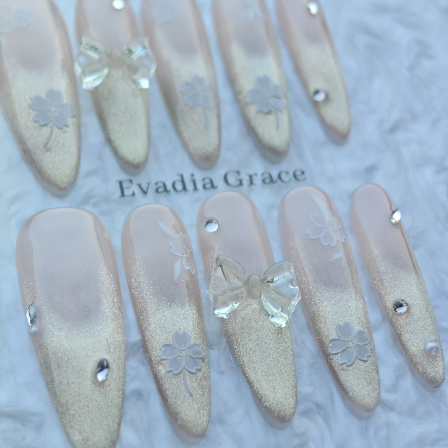 Blossom Glow Nails – Nude Gold Gradient Press-On Nails with Clear Bow & White Sakura Art | Elegant Japanese Floral Nails by Evadia Grace