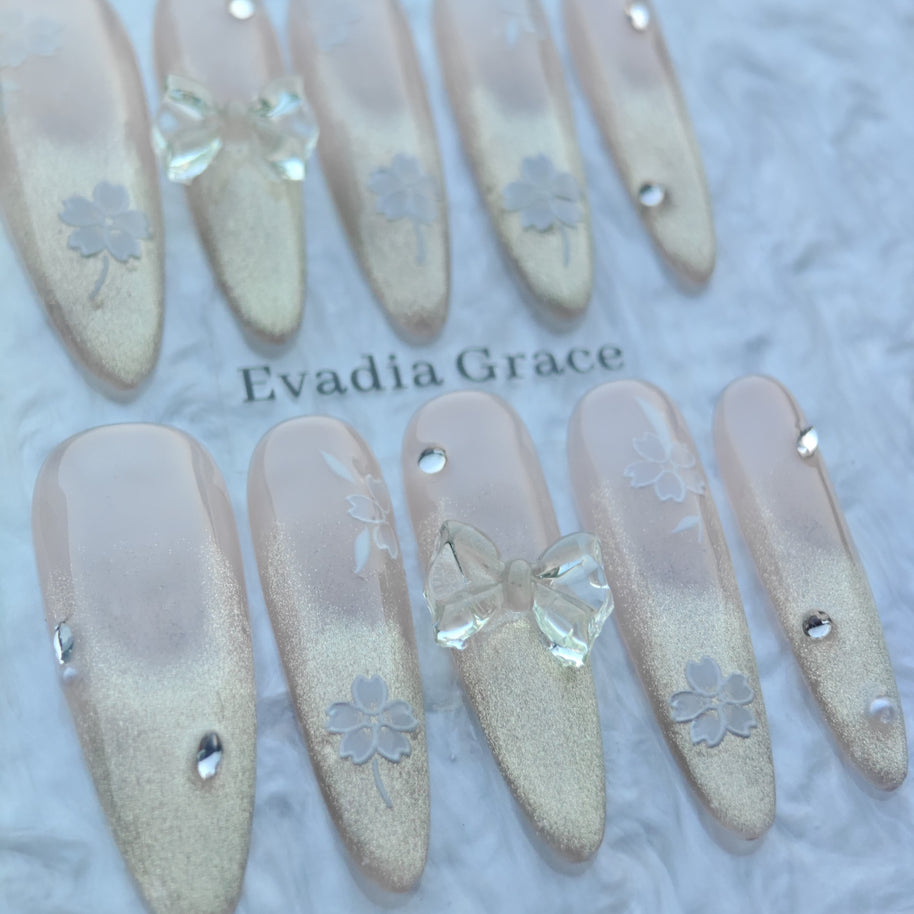 Blossom Glow Nails – Nude Gold Gradient Press-On Nails with Clear Bow & White Sakura Art | Elegant Japanese Floral Nails by Evadia Grace