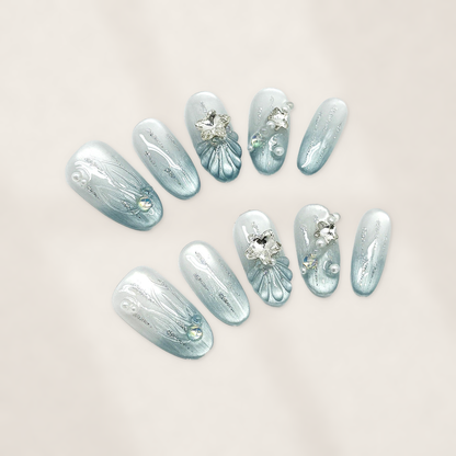 Glacial Mermaid Blue Oval Press-On Nails with Pearlescent Cat-Eye Shimmer, Sculpted Shells, Stars, and Silver Charms 22mm